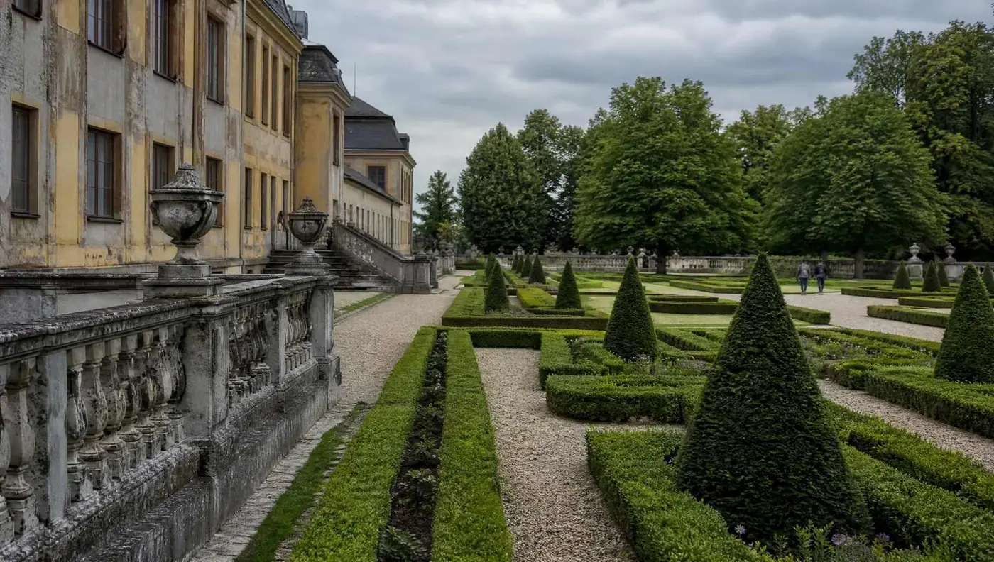 Clipped hedges, gravel paths and a stone balustrade in a formal baroque garden