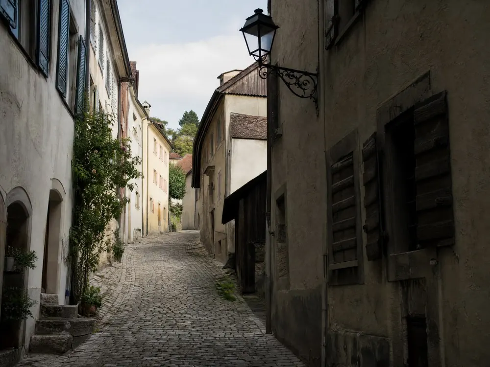 A cobbled lane between shuttered houses